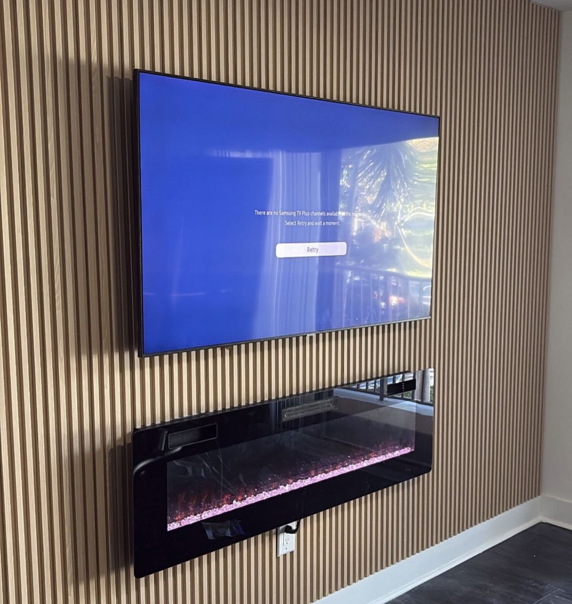 Wood slat wall with a mounted TV and a wall fireplace below